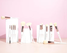 Luxe Makeup Brush Set brushes standing in white holders on a pink background
