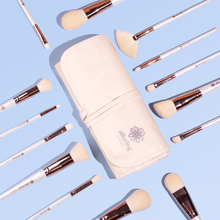 Luxe Makeup Brush Set brushes and cream roll-up case laid out on a blue background